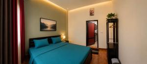 a bedroom with a blue bed and a mirror at Beach Guest House Addalaichenai in Addalachenai
