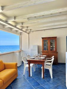 a dining room with a table and chairs and the ocean at Vivi Marettimo in Marettimo