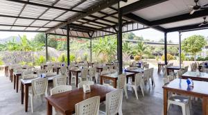 a restaurant with wooden tables and white chairs at Gypsy Sea View Resort- Phi Phi Island in Phi Phi Islands