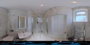 a white bathroom with a shower and a sink at Avoca House in Dublin