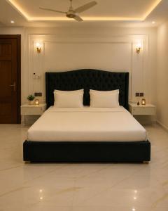 a bedroom with a large bed with two tables at Emerald Villa Islamabad in Islamabad