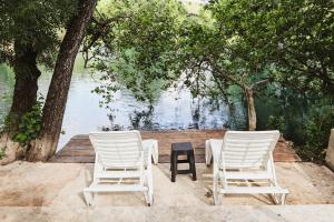 two white chairs and a table next to a body of water at Vikendica Trebižat river in Čapljina +13 photos