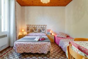 a bedroom with two beds and two tables and two lamps at Côté Jardin in Bédoin