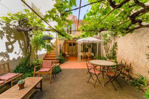 an outdoor patio with a table and chairs at Côté Jardin in Bédoin