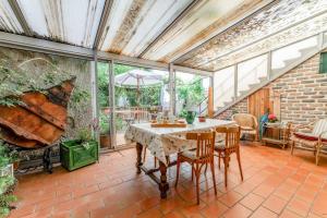 a conservatory with a table and chairs on a brick floor at Côté Jardin in Bédoin
