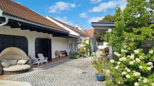 a patio of a house with a couch and chairs at Ferienwohnungen Proschahaus in Eisenberg an der Pinka