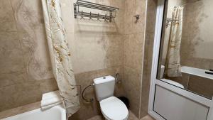a bathroom with a toilet and a sink and a tub at Giza Grand Hotel in Tashkent
