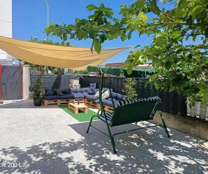 a patio with a hammock and a couch in a backyard at Vacanze da Paola in Campomarino
