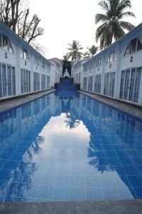 a swimming pool in front of a building at Royal Bishnu in Calangute