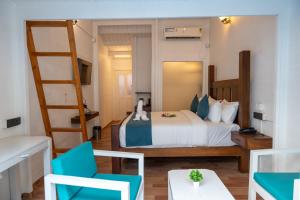 a bedroom with a bed with blue chairs and a ladder at Royal Bishnu in Calangute +22 photos