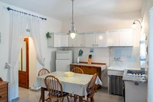 a kitchen with a table and chairs and a kitchen with white cabinets at Le Cote di Seccheto - Goelba in Seccheto