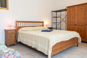 a bedroom with a large bed and wooden furniture at Le Cote di Seccheto - Goelba in Seccheto