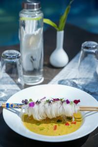 a white plate with a dessert on a table with chopsticks at Royal Bishnu in Calangute
