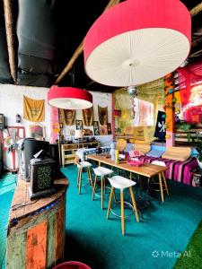 a room with a table and some chairs and a table and lights at Bell Tent Lovers by Casa das Artes in Luz de Tavira