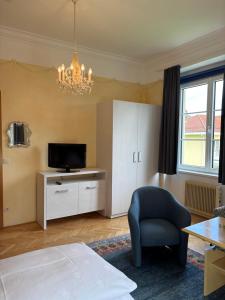 a bedroom with a bed and a tv and a chair at Villa Christina in Pörtschach am Wörthersee