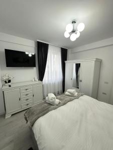a bedroom with a large bed with two towels on it at Apartament Bucovina Bellevue in Gura Humorului