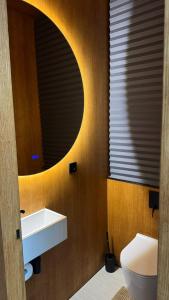 a bathroom with a white sink and a mirror at Aura Glemp & SPA in Laukbeitini