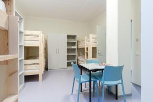 a dining room with a table and chairs and bunk beds at Märjamaa spordihoone in Märjamaa