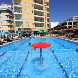 a swimming pool with a red object in the water at Niko Apartaments Shengjin in Shëngjin +7 photos