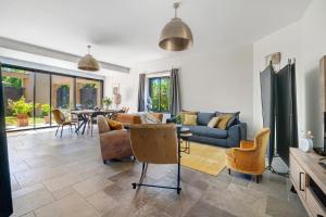 a living room with a couch and chairs and a table at Le Logis des Abeilles in Lapenne