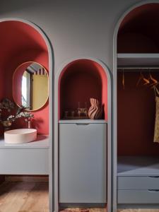 a bathroom with two arch shaped walls and a mirror at Memories Apartments - Explore & Recharge in Laganas