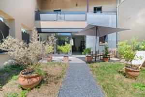 a patio with an umbrella and some potted plants at Le Logis des Abeilles in Lapenne