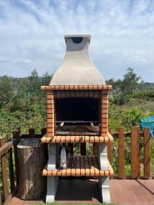 a outdoor pizza oven sitting on a wooden deck at Casa do Canastro in Sever do Vouga