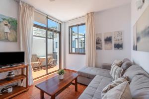 a living room with a couch and a tv at Casa Perla in Playa de Santiago