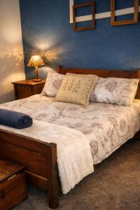 a bed in a bedroom with a blue wall at The Big Tree Cottage in Graafwater