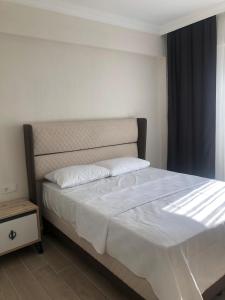 a bedroom with a large bed with white sheets and a window at Muğladaki Eviniz in Muğla