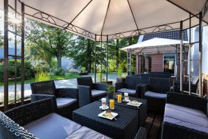 a patio with chairs and tables and an umbrella at Krasicki Hotel Resort & Spa in Świeradów-Zdrój