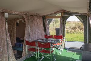 a table and chairs in a tent at Glamlodge Ameland direct aan het strand in Nes