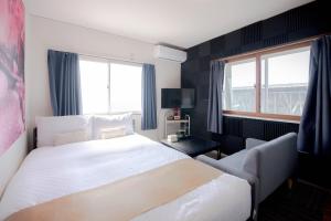 a bedroom with a large white bed and a window at Ponpon Railway House in Kyoto