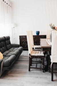 a living room with a couch and a piano at Aurega Vintage Bedrooms by Lethes Legacy in Ponte de Lima +32 photos