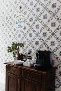 a wooden cabinet with dishes on it in a room with wallpaper at Aurega Vintage Bedrooms by Lethes Legacy in Ponte de Lima