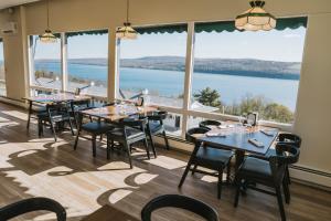a dining room with tables and chairs and a large window at The Hotel Laurel at Seneca in Watkins Glen