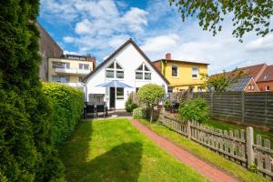 a white house with a fence at Nordsee-Apartments Hinrichsen in Husum