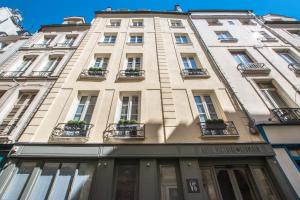a tall building with windows and potted plants on it at Victoire & Germain in Paris