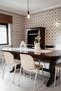 a dining room with a table with chairs and a fireplace at Aurega Vintage Bedrooms by Lethes Legacy in Ponte de Lima