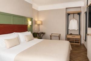 a hotel room with a large white bed and a table at Honest Sevilla Hotel in Seville +30 photos