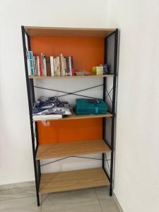 a book shelf with books on it next to a wall at Résidence Maeva in Mtsamboro