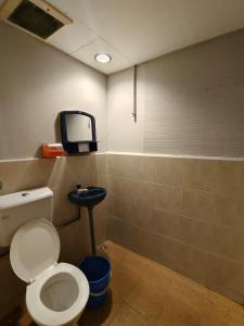 a bathroom with a toilet and a tv on the wall at Sea Lion Pulau Ketam Inn in Bagan Teochew