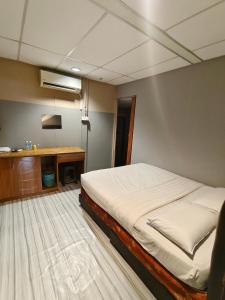 a bedroom with a bed and a desk in it at Sea Lion Pulau Ketam Inn in Bagan Teochew