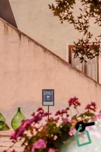 a sign in front of a building with pink flowers at Hotiday Grosseto Podere in Grosseto