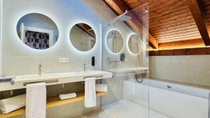 a bathroom with two sinks and two mirrors at Soho Boutique La Harinera in Valladolid