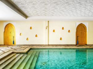 a swimming pool in a building with a ceiling at Sofitel Marrakech Palais Impérial & Spa in Marrakesh