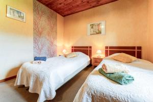 two twin beds in a room with two lamps at Le Mas Perdu Gîte Studio Parme in Saint-Christol-lès-Alès