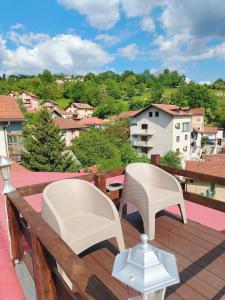 two chairs on a deck with a view of a city at Sarajevo Old Town 1 Free Parking & RoofTop View in Sarajevo
