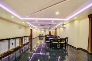 a dining room with tables and chairs and purple lights at Super Hotel O The Dev Regency in Patna
