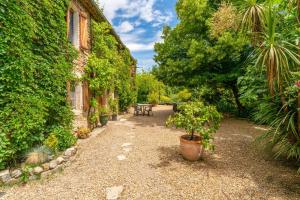 a garden with a table and a bench next to a building at Le Mas Perdu Gîte Studio Parme in Saint-Christol-lès-Alès